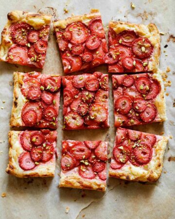 Strawberry Tart with pistachios on a parchment sheet.