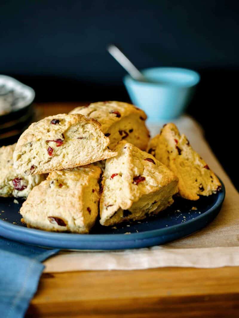 Cranberry orange scones piled on a plate ready to be served. 