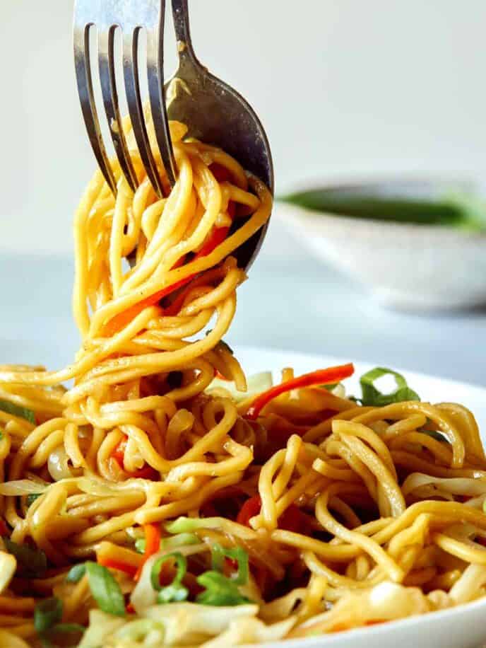 A close up of Chow Mein Noodles being served from a platter. 