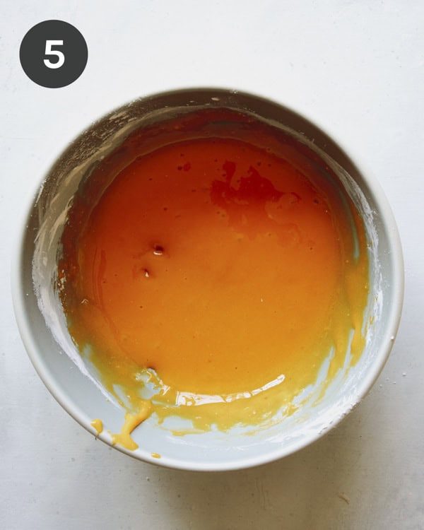 Egg yolks and cornstarch mixed together in a bowl to make pudding. 