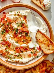 Whipped goat cheese with a crostini dipped in it.