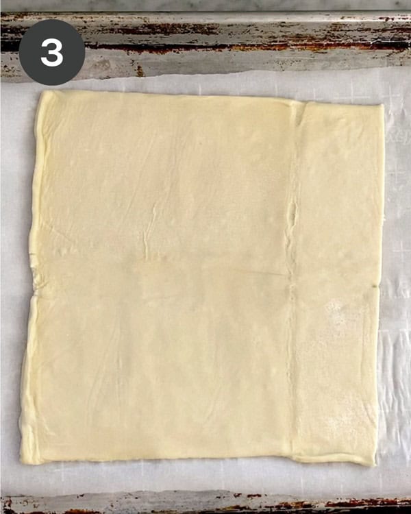 Raw puff pastry on a baking sheet.