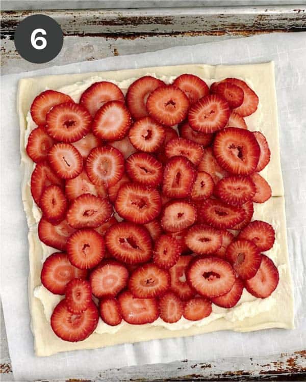 A puff pastry sheet layered with sliced strawberries.