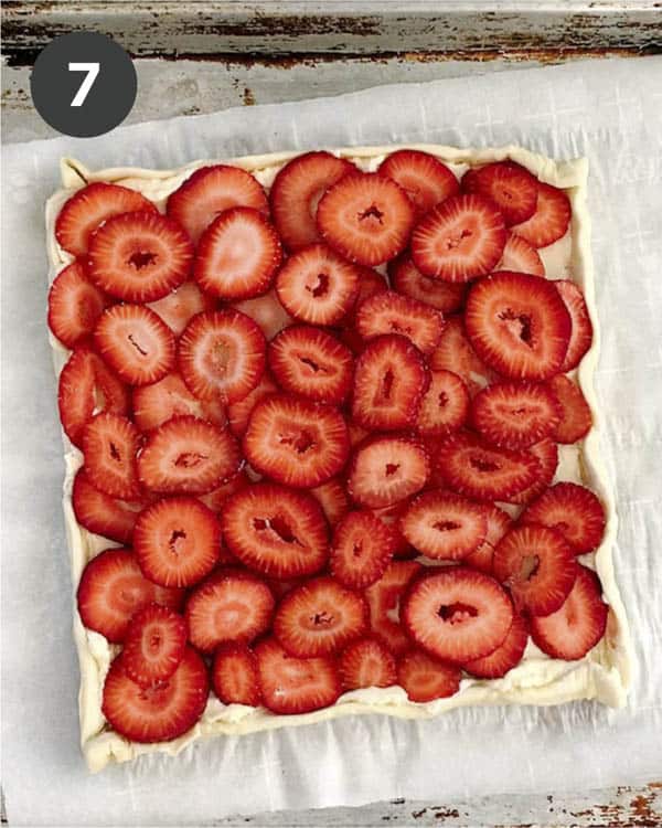 A puff pastry sheet layered with sliced strawberries. 