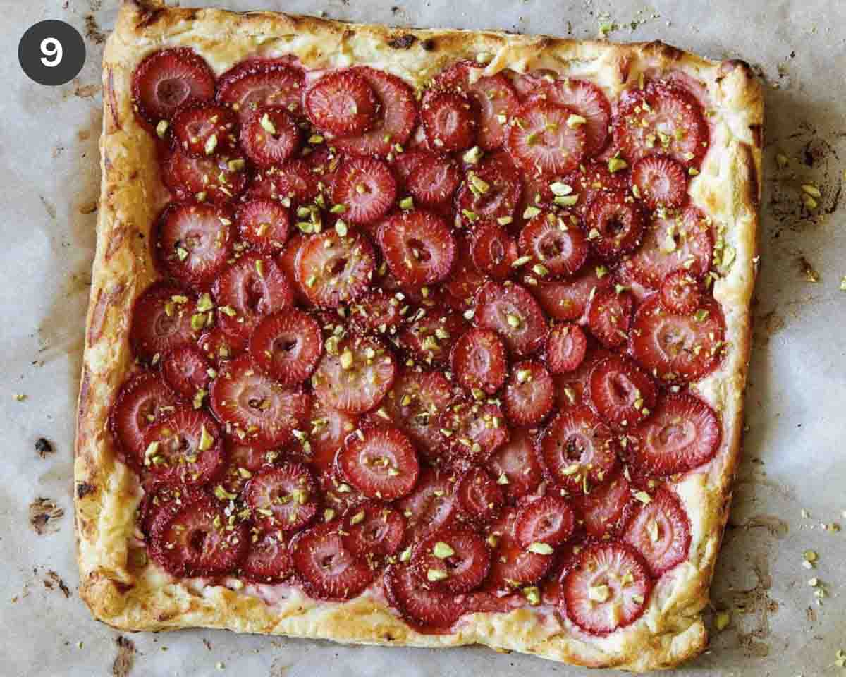 A strawberry tart right out of the oven  on a piece of parchment. 