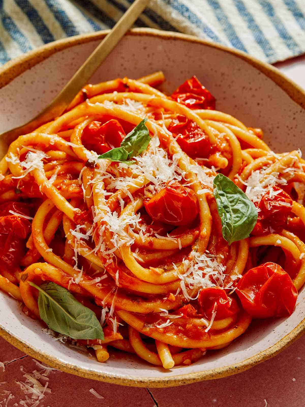 Tomato sauce pasta in a bowl with a fork on the side.