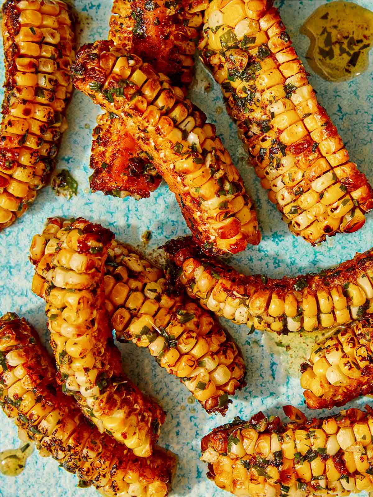 Close up on a platter for corn ribs with butter drizzled over them.