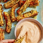 Air fryer corn ribs recipe on a platter with a dipping sauce.