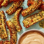 Air Fryer corn ribs on a platter with a dipping sauce.