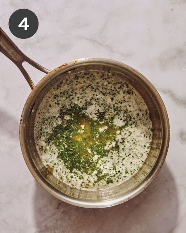 Melted butter with herbs in a pot.