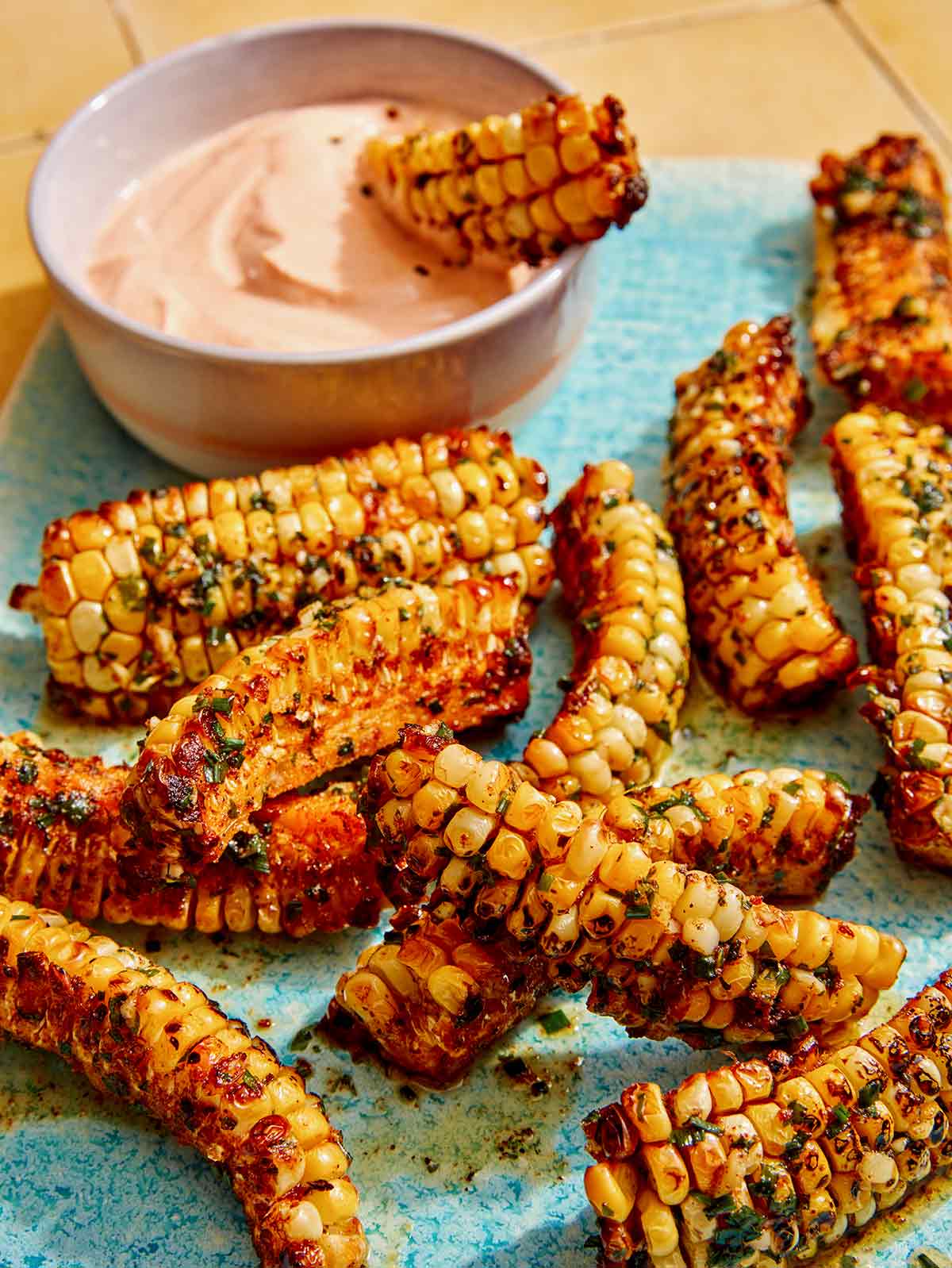 Corn ribs on a platter with dipping sauce.