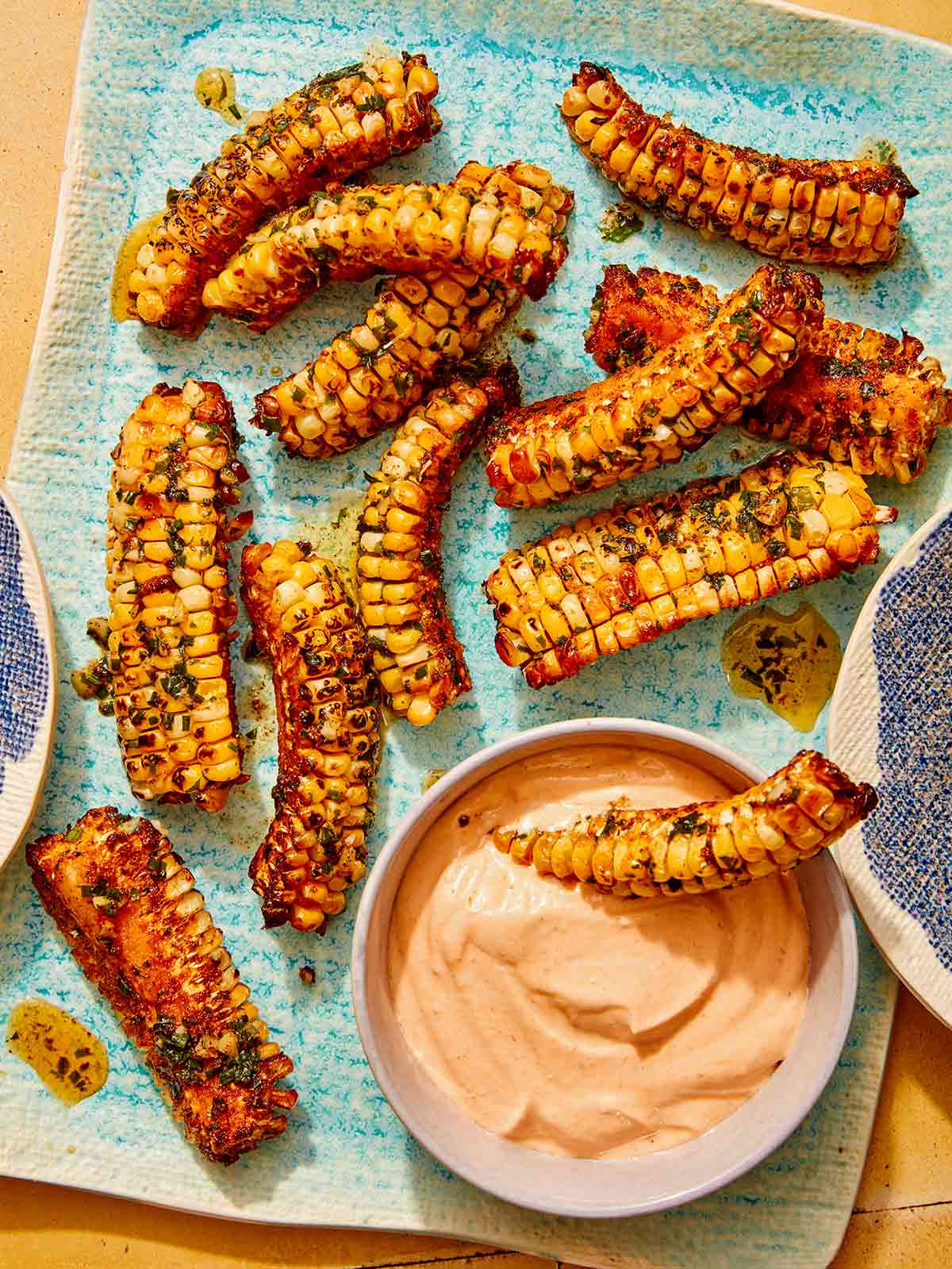 Corn ribs recipe on a platter with a dipping sauce. 