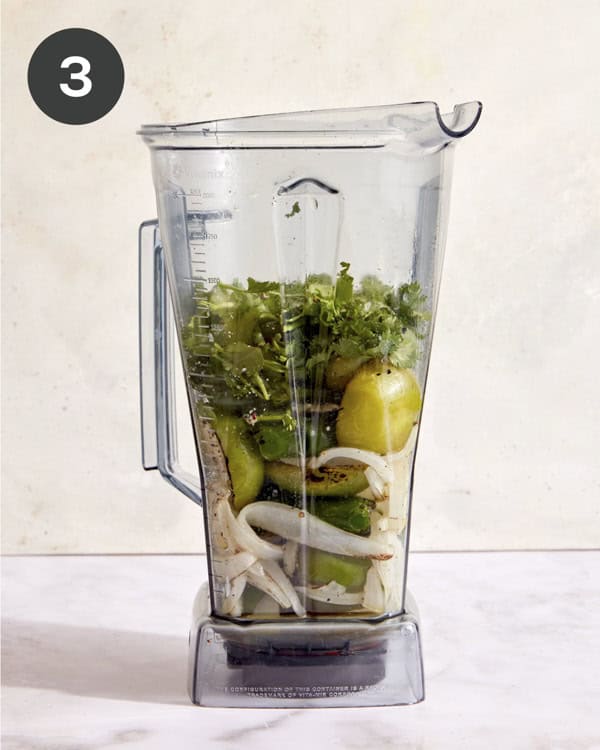 Tomatillo salsa ingredients in a blender ready to be blended.