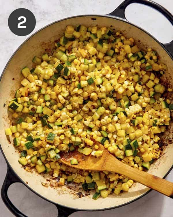 Zucchini and squash in a skillet being cooked.