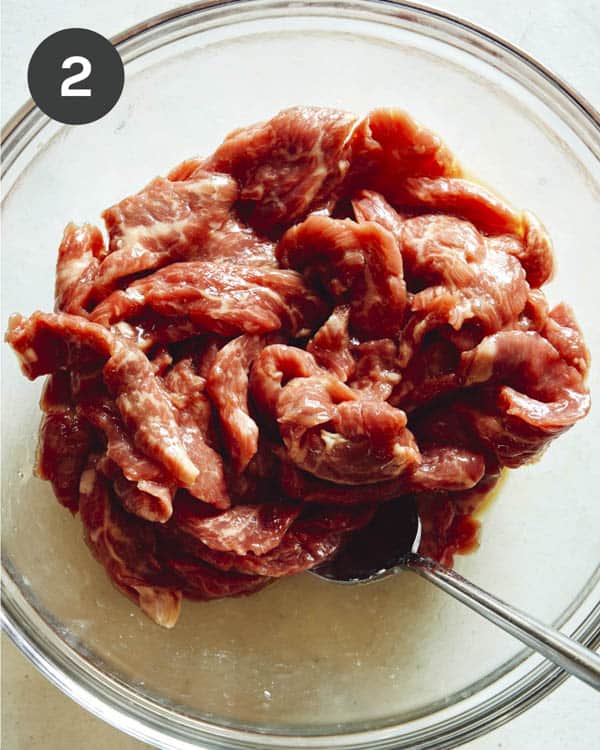 Szechuan beef marinating in a bowl. 