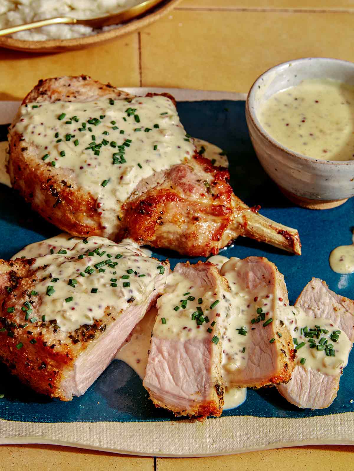 Air fryer pork chops on a platter with a cream sauce.