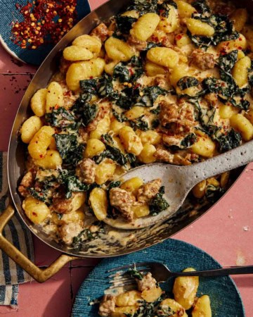 Baked gnocchi being scooped out onto a plate.