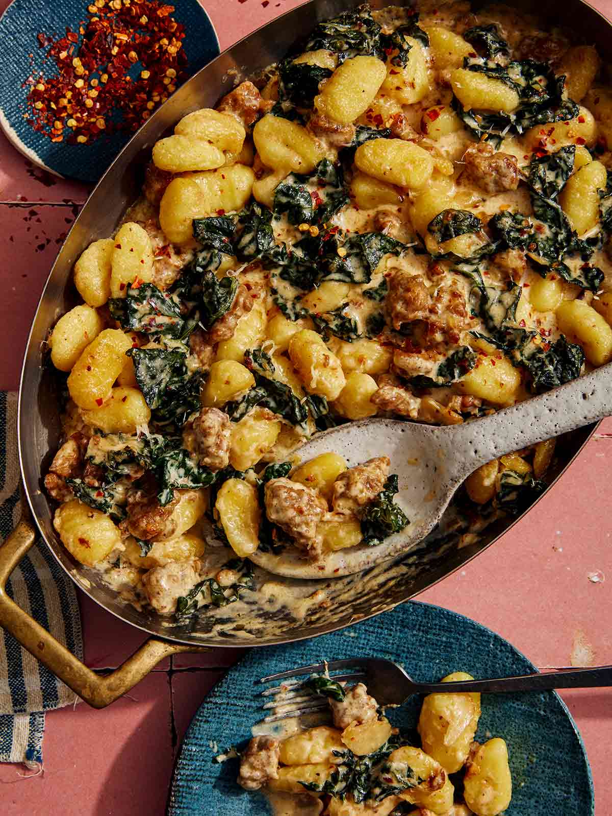 Baked gnocchi being scooped out onto a plate. 