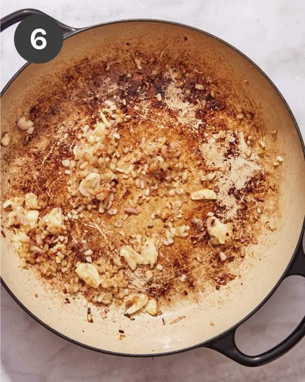 Shallots and garlic cooking in a skillet. 