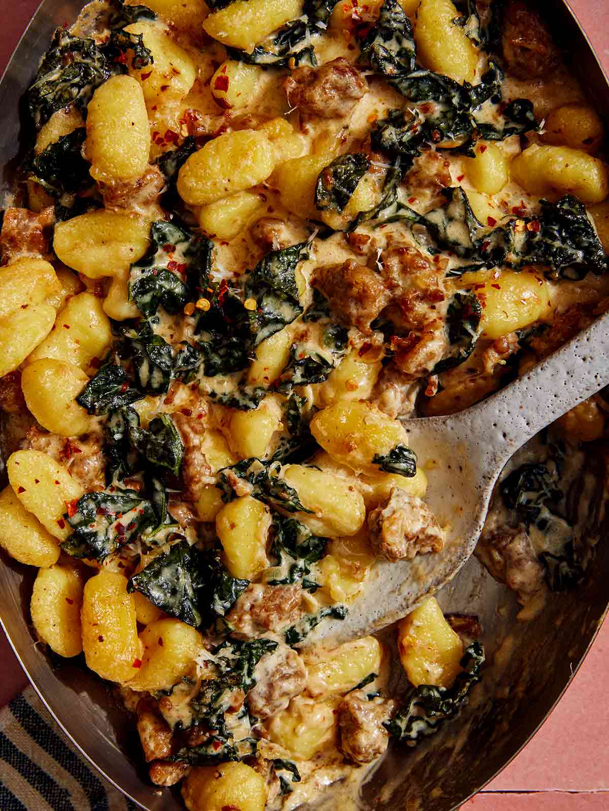 Close up on baked gnocchi being scooped out. 