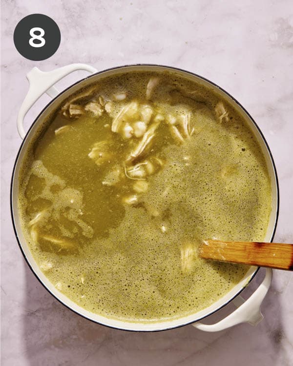 Chicken pozole verde simmering in a pot. 