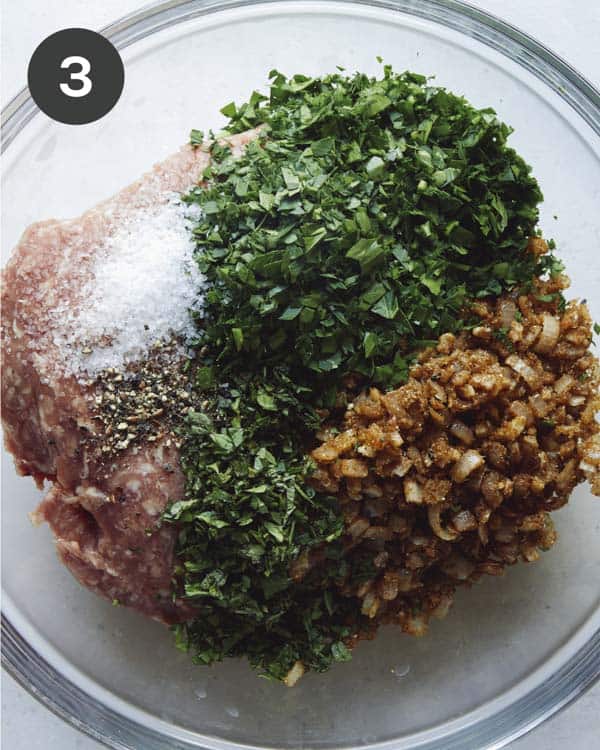 Ground lamb with seasoning in a glass bowl.