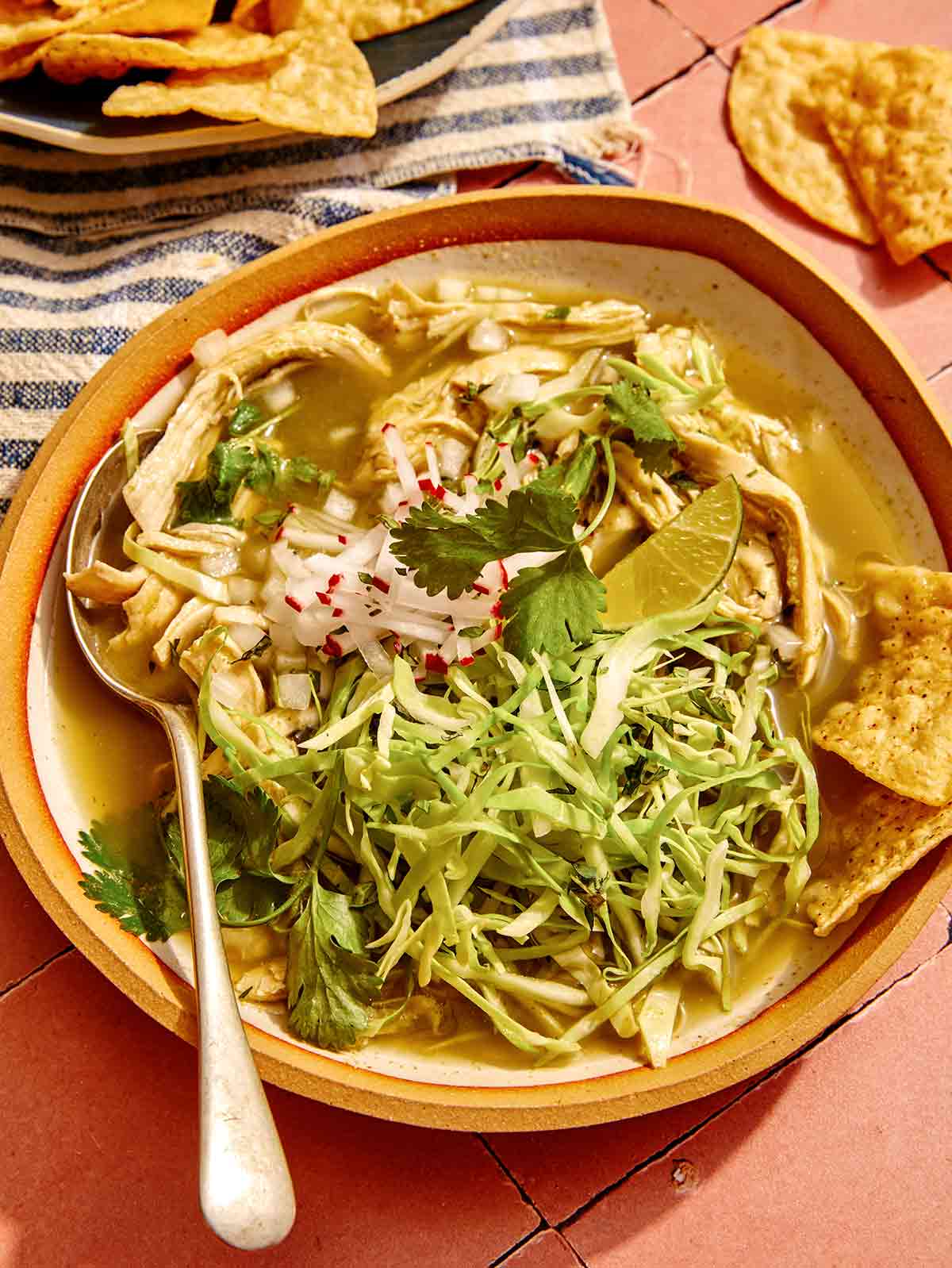 Chicken pozole verde in a bowl with a spoon.