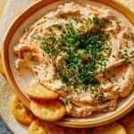 Smoked salmon dip recipe in a bowl with crackers.