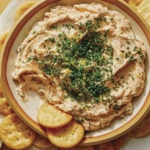 Smoked Salmon Dip recipe in a bowl with crackers on the side.