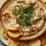 Smoked Salmon Dip recipe in a bowl with crackers on the side.