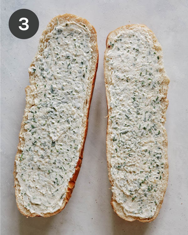 Garlic bread butter spread onto bread ready to go into the oven.